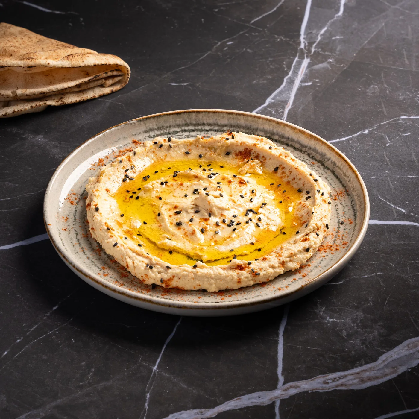 Hommos Pastrami, hommos tiède parsemé de graines de nigelle et d’huile pimentée